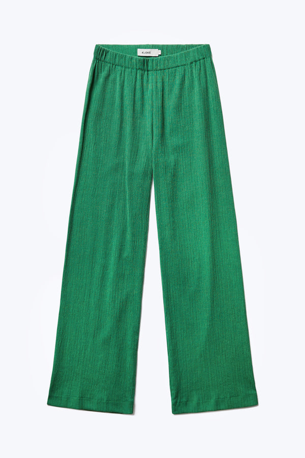 Flat lay of the front of the Oracle Crinkle Pant Green, a slinky, slim fit pant with an elasticated waistband for comfort. 