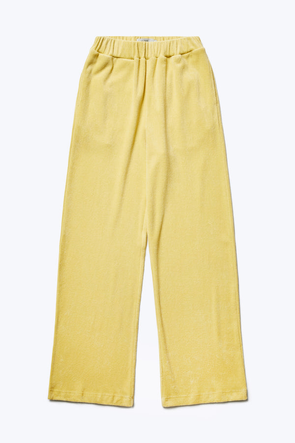 The front of the Prone Towelling Track Pant, a slouchy track pant with an elasticated waist band. Crafted from an  Okeo-tex standard cotton terry in Butter Yellow. 