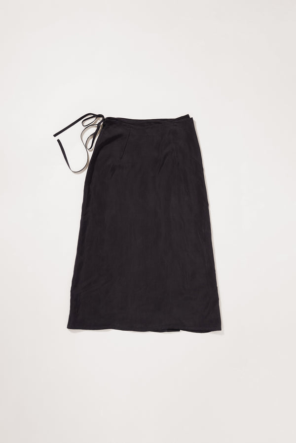 Flat back of the Purview Skirt in Vintage Black Cupro showing wrap A-line midi silhouette. 