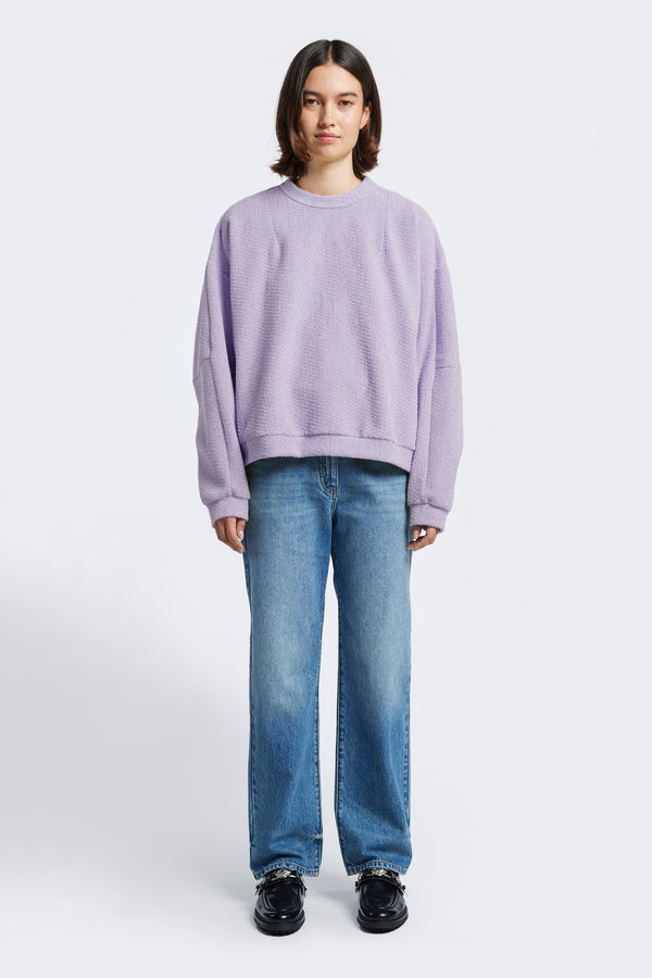 The Respite Sweater in loop front jersey in Lilac Purple, is a cropped style jumper with panelled sleeves, front darts at the collar and back straight dart detail. 