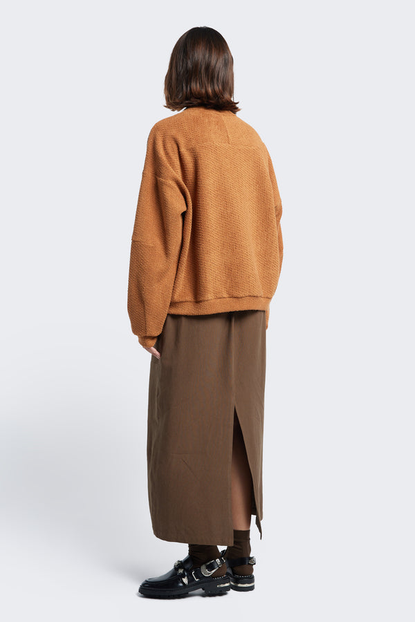 The back of the Respite Sweater Rusty Brown, a cropped jumper with a relaxed silhouette and back straight dart detail. 