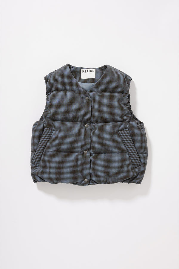 Flat front of the blue Static Quilted Down Vest in Kloke's signature seersucker gingham with a V-neck, snap-front closure and front welt pockets.