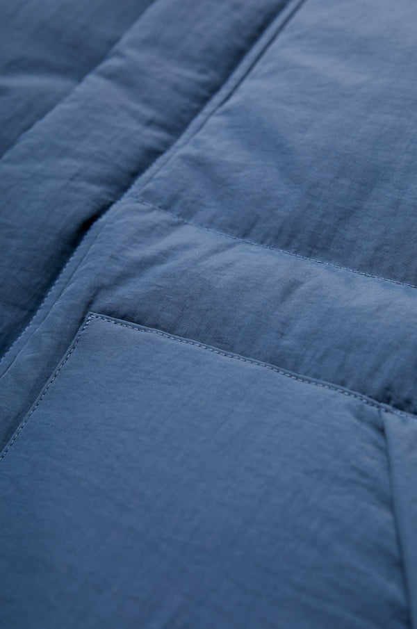 The Stay Quilted Puffer Vest Blue is a quilted down vest. Made from 100% Recycled Nylon, Lining 100% Recycled Nylon, 100% Post Consumer Down Fill.