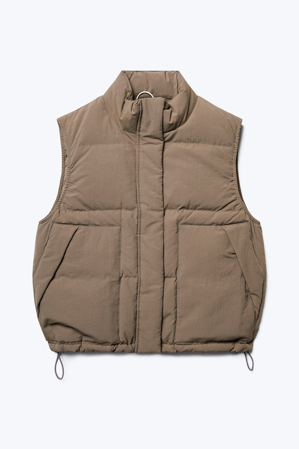 The front of the Stay Quilted Puffer Vest Brown, is a quilted down vest with high neckline, centre zip and press stud closure, elasticated armholes, side pockets and elastic waist pulls with toggles.