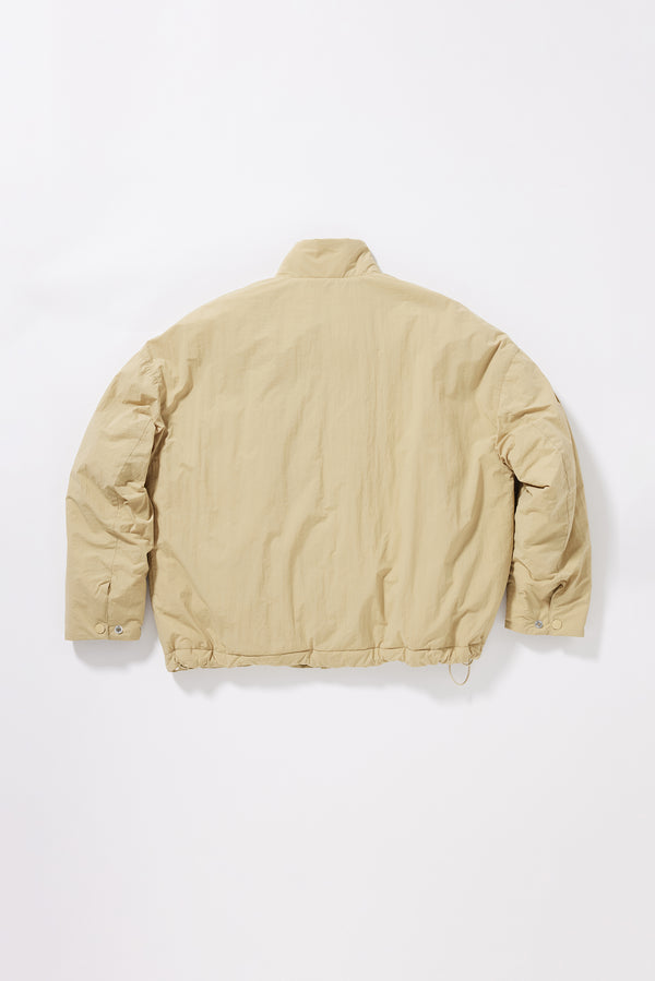 Flat black of sand beige Surge Quilted Jacket showing dropped shoulders, gently sculpted sleeves and relaxed quilted silhouette