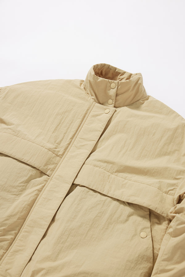 Close-up of military-style tab collar on the sand beige Surge Quilted Jacket