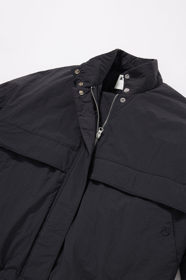 Close-up of military-style tab collar on the black Surge Quilted Jacket