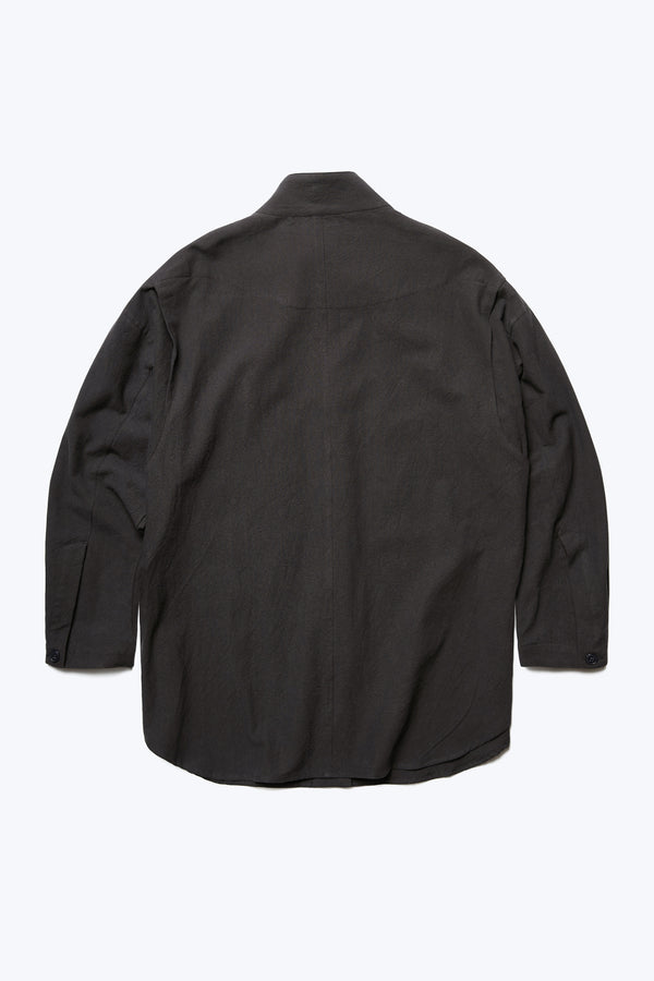 The back of the Tenet Blouson Shirt Black, a long sleeve shirt with a relaxed silhouette. Features back shoulder vent detail and button cuff. Crafted from a textural cotton fabric. 