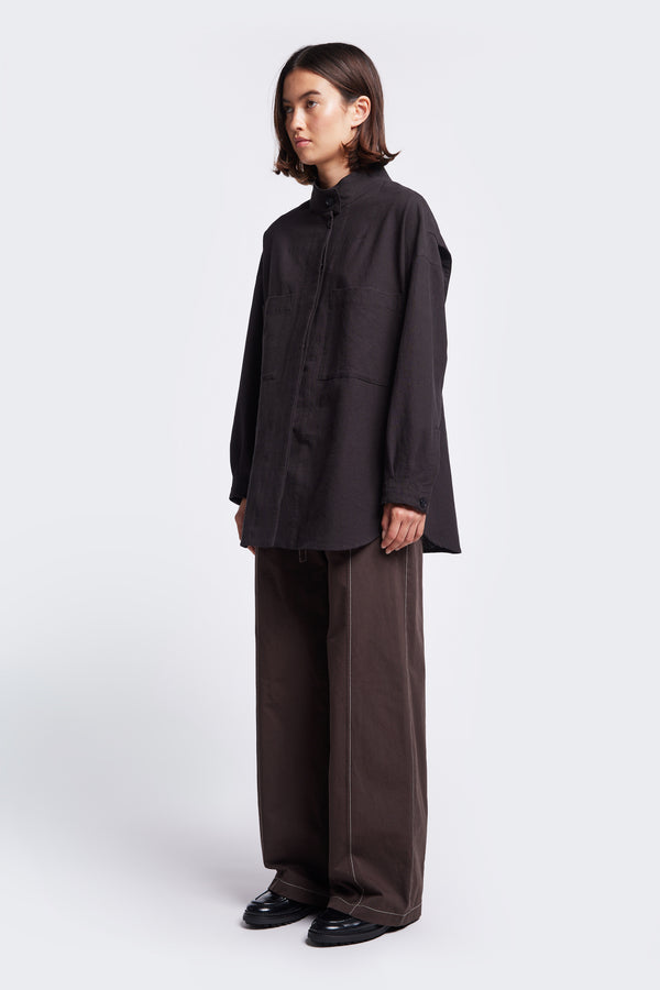 The Tenet Blouson Shirt Black is a long sleeve shirt with a relaxed silhouette, centre concealed button placket, two front patch pockets at the chest and scooped hemline. Made from a textural cotton fabric. 