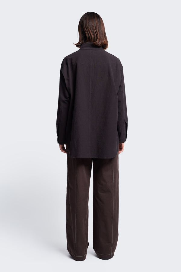 The back of the Tenet Blouson Shirt Black, a relaxed silhouette, long sleeve shirt with scooped hemline. 