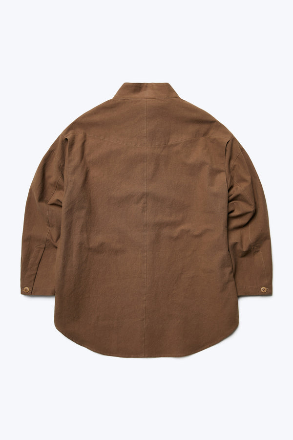 The back of the Tenet Blouson Shirt Brown, a long sleeve shirt with a relaxed silhouette. Features back shoulder vent detail and button cuff. Crafted from a textural cotton fabric. 