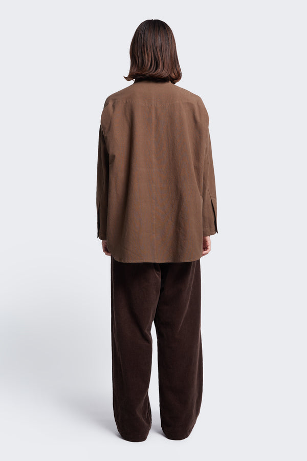 The back of the Tenet Blouson Shirt Brown, a relaxed silhouette, long sleeve shirt with scooped hemline.