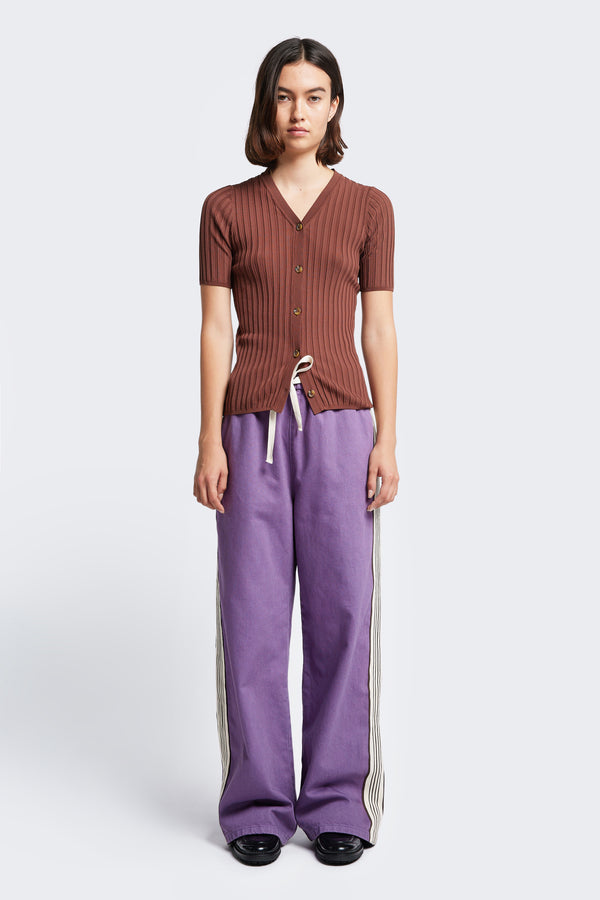 The Tribute Side Trim Pant is a casual wide leg pant with an elasticated waist and tie. Made from a soften cotton in Purple and finished with side stripe detail. 