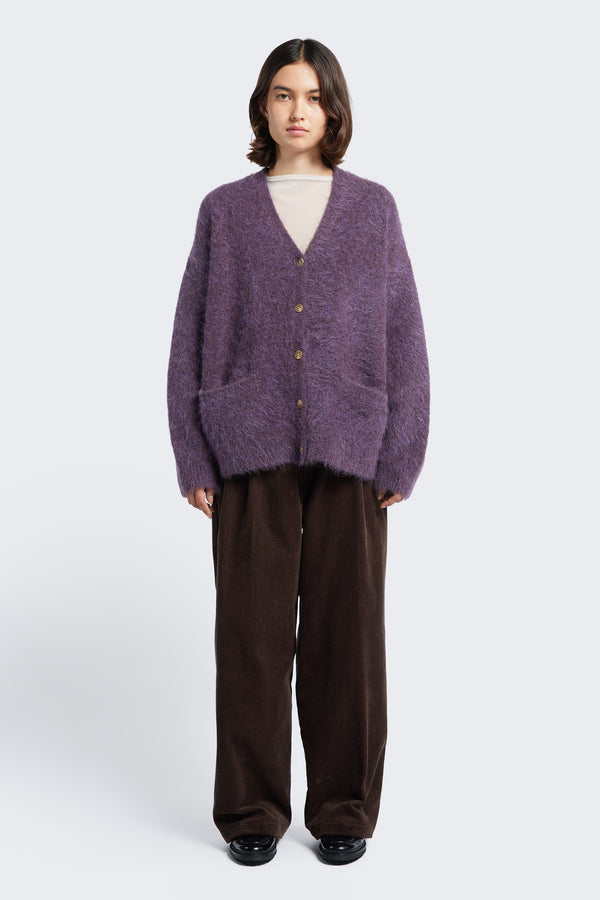 The Vessel V Neck Cardigan is a loose and fuzzy knit made from a special Alpaca blend in Purple.  Finished with button closure, dropped shoulder and two welt pockets at the front. This cardigan is designed to be worn big. 