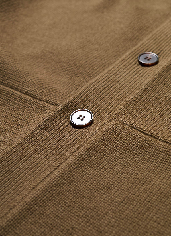 Close up details of The Anvil Collar Cardigan in Brown Olive, a heavier cotton knit styled as a jacket or cardigan, featuring a built-in collar, practical front pockets, and standout design details. Available in 5 sizes. 