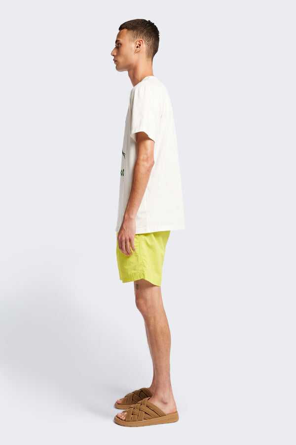 Side view of Bacino T, a classic cut t-shirt in a soft cotton jersey, with a thick rib neckline and straight hem. With this seasons Kloke Bacino placement print in green. Available in 5 sizes. 