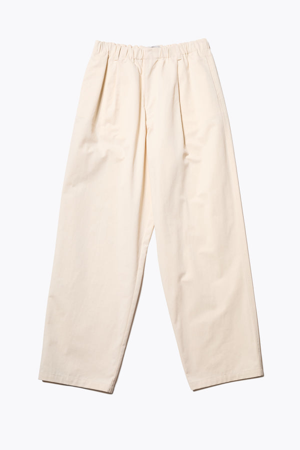 The Boulder Pleat Pants in Chalk Beige, crafted from cotton herringbone twill, featuring side slant pockets, back patch pockets, and an elastic waistband with internal pull. Available in 5 sizes. 