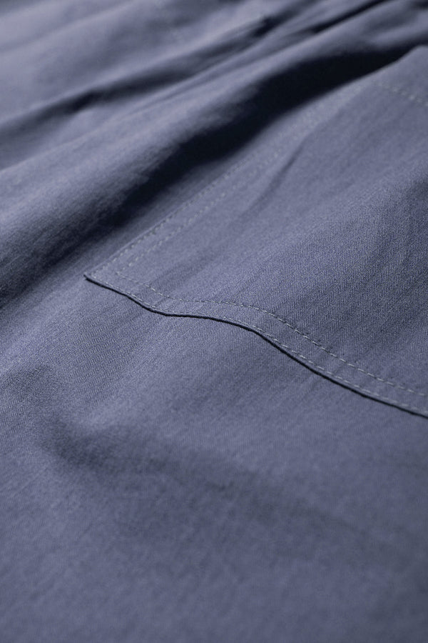 Close up Fabric detail of the Degree Pleat Short, a laidback and adaptable easy to weather summer short. Crafted in a blue washed cotton herringbone twill. Available in 5 sizes. 