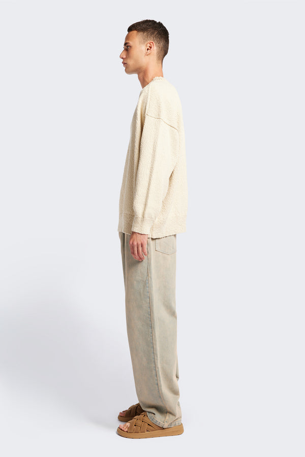 Side of the ecru Hill Slub Sweater in textured cotton slub knit with an oversized fit, raglan sleeves, and ribbed trim at the hem and cuffs.
