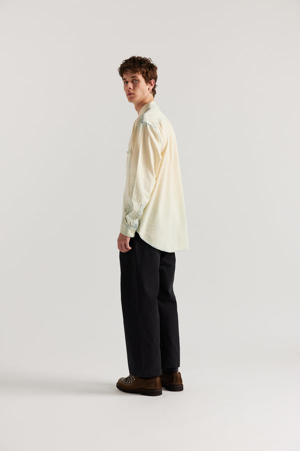 Side back view of male model in Black Lenz Pant with straight-leg silhouette, front patch pockets and twin-needle topstitch detail.