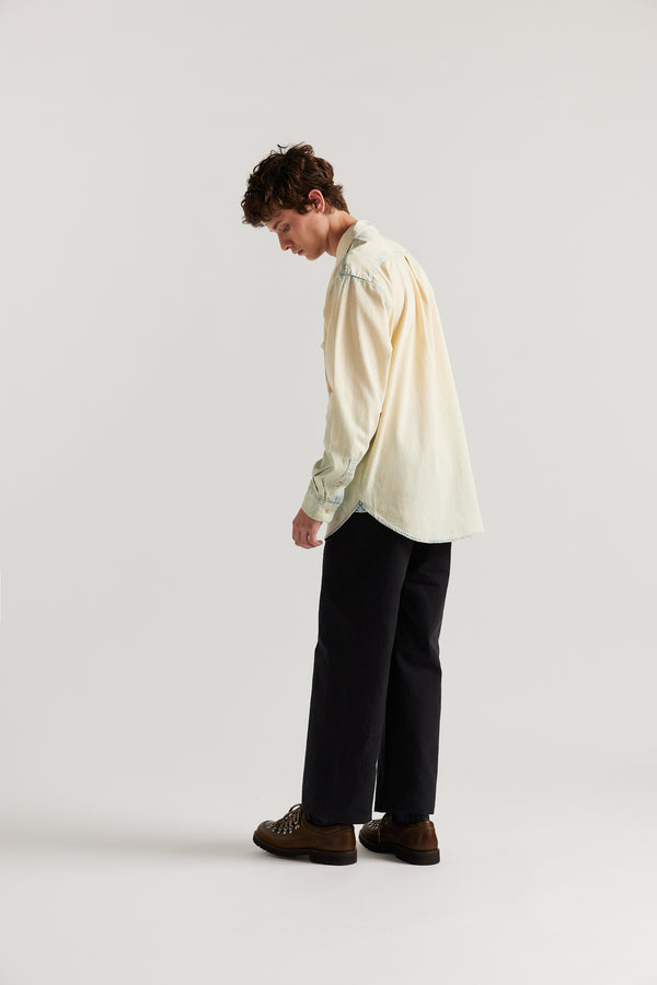 Side back view of male model in Black Lenz Pant with straight-leg silhouette, front patch pockets and twin-needle topstitch detail.