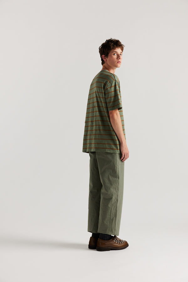 Back view of male model in Olive Lenz Pant with straight-leg silhouette, front patch pockets and twin-needle topstitch detail.