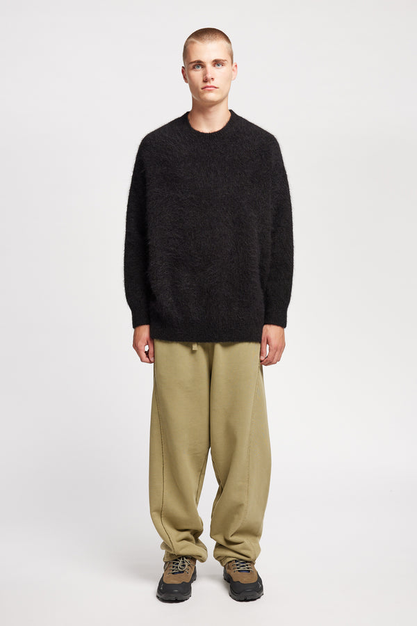 Front of Model wearing oversized fluffy knit crew neck sweater in Black 