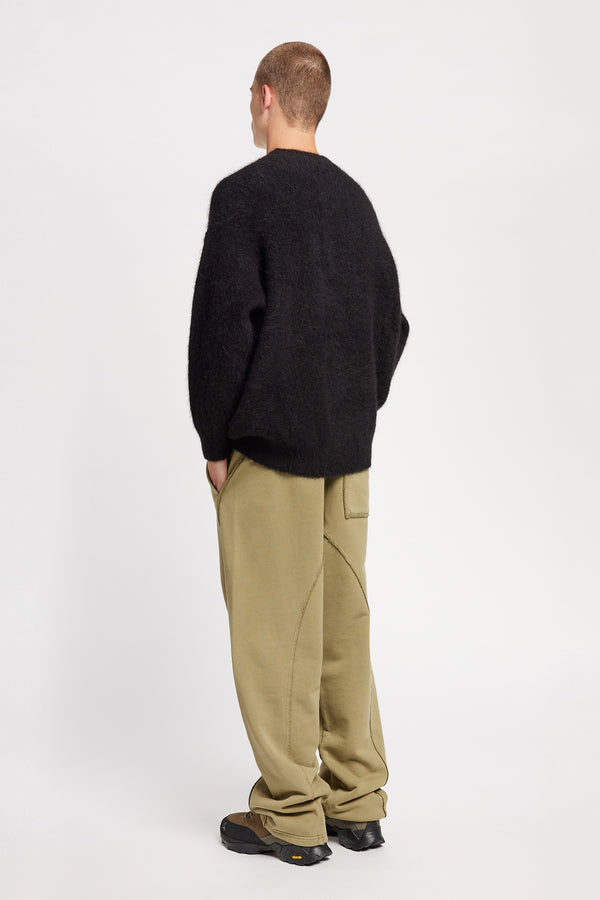 Back angle of Model wearing oversized fluffy knit crew neck sweater in black. 
