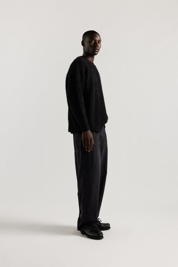 Side of Male Model wearing oversized brushed alpaca blend knit crew neck sweater in Black 