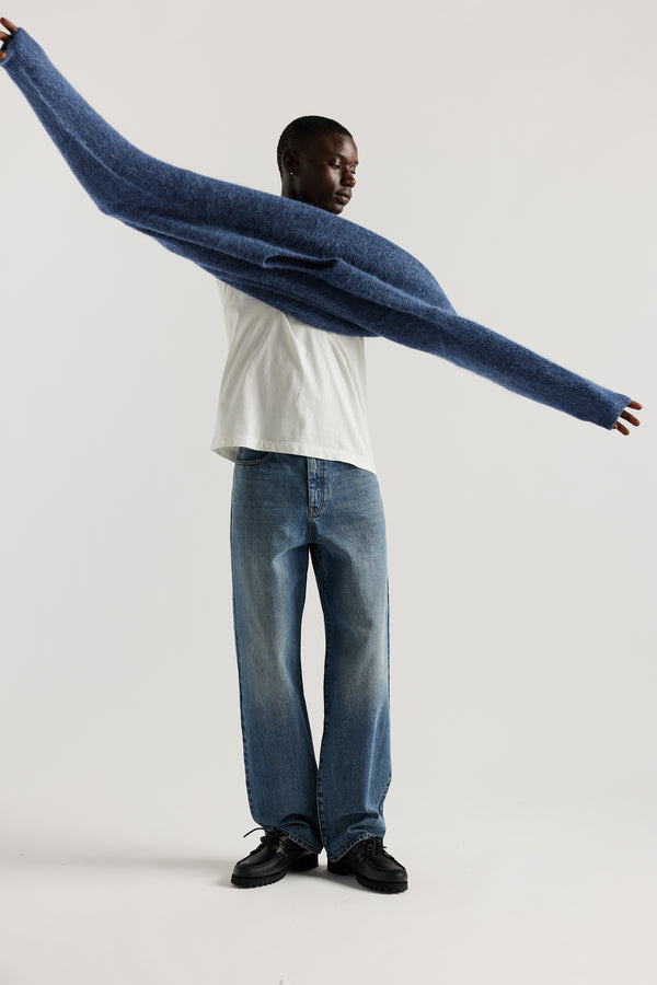 Front of Model wearing oversized fluffy alpaca  knit crew neck sweater in indigo blue. 

