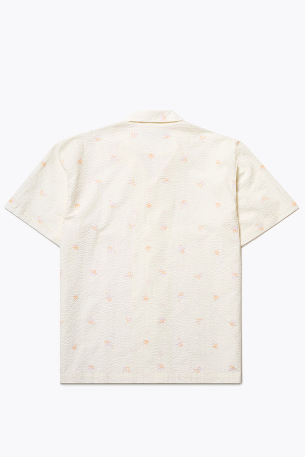 Flat back of the Mirari in Ecru floral, a relaxed short-sleeve open-collar camp shirt made from soft textured cotton seersucker, offering a laid-back fit. Available in 5 sizes. 