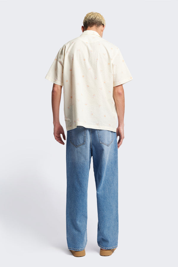 Back of the Mirari in Ecru floral, a relaxed short-sleeve open-collar camp shirt made from soft textured cotton seersucker, offering a laid-back fit. Available in 5 sizes. 