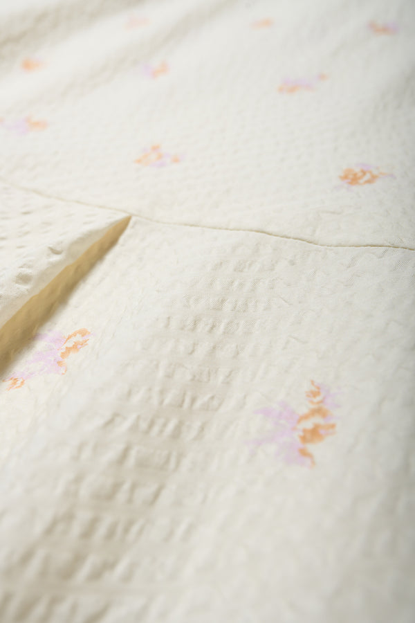 Close up of the Mirari in Ecru floral, a relaxed short-sleeve open-collar camp shirt made from soft textured cotton seersucker, offering a laid-back fit. Available in 5 sizes. 