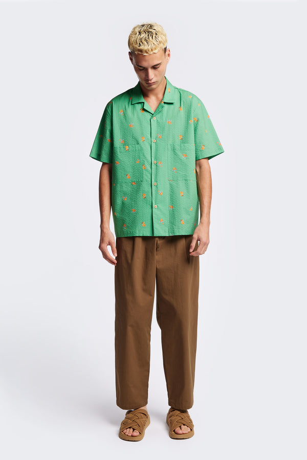 Front of the Mirari in Green floral, a relaxed short-sleeve open-collar camp shirt made from soft textured cotton seersucker, offering a laid-back fit. Available in 5 sizes. 