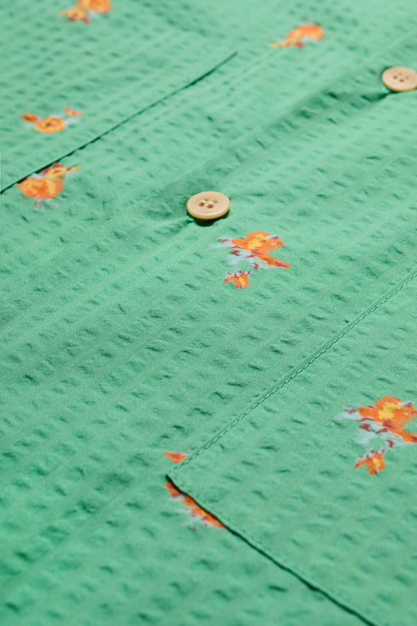Close up of the Mirari in Green floral, a relaxed short-sleeve open-collar camp shirt made from soft textured cotton seersucker, offering a laid-back fit. Available in 5 sizes. 