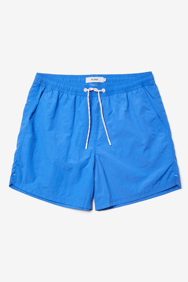 The New Wave Short in Lapis Blue. Swim shorts with elastic drawstring waist, internal mesh support, and front slant pockets. Available in 5 sizes.