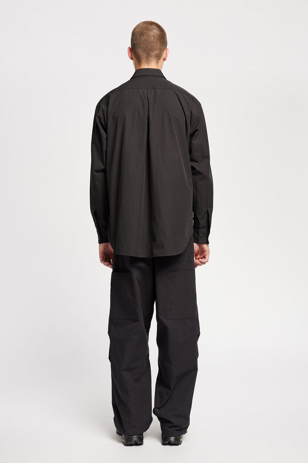 Back of the Model wearing the Offset Shirt in a black heavyweight cotton, featuring a relaxed fit and utility chest pockets.