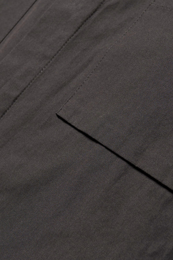 Close up fabric shot of the Offset Shirt in a  black heavyweight cotton, featuring a relaxed fit and utility chest pockets.