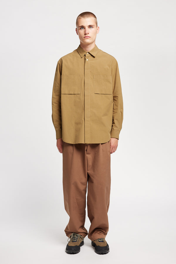 Front of the Model wearing the Offset Shirt in a dusty olive heavyweight cotton, featuring a relaxed fit and utility chest pockets.