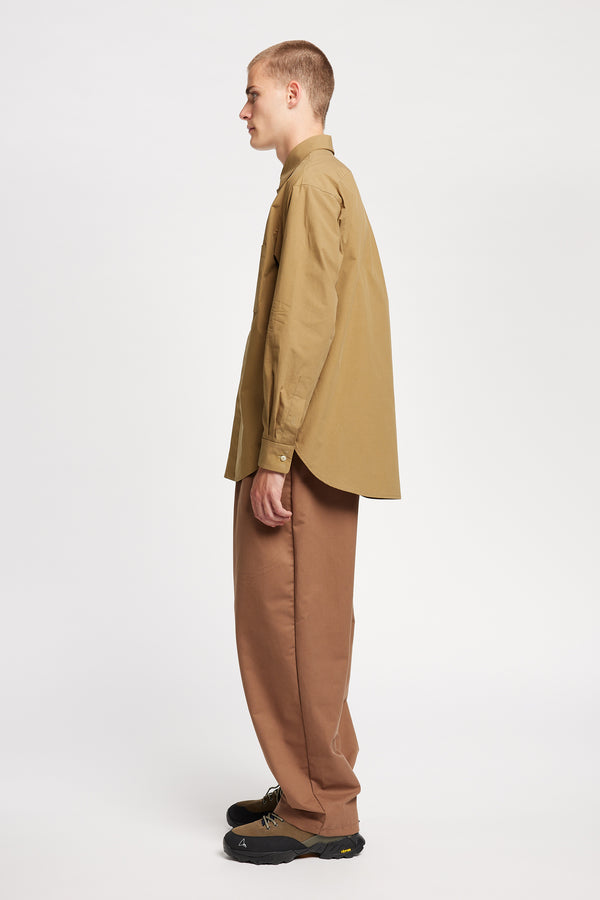 Side of the Model wearing the Offset Shirt in a dusty olive heavyweight cotton, featuring a relaxed fit and utility chest pockets.