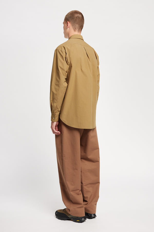 Back Angle of the Model wearing the Offset Shirt in a dusty olive heavyweight cotton, featuring a relaxed fit and utility chest pockets.