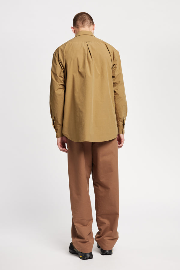 Back of the Model wearing the Offset Shirt in a dusty olive heavyweight cotton, featuring a relaxed fit and utility chest pockets.