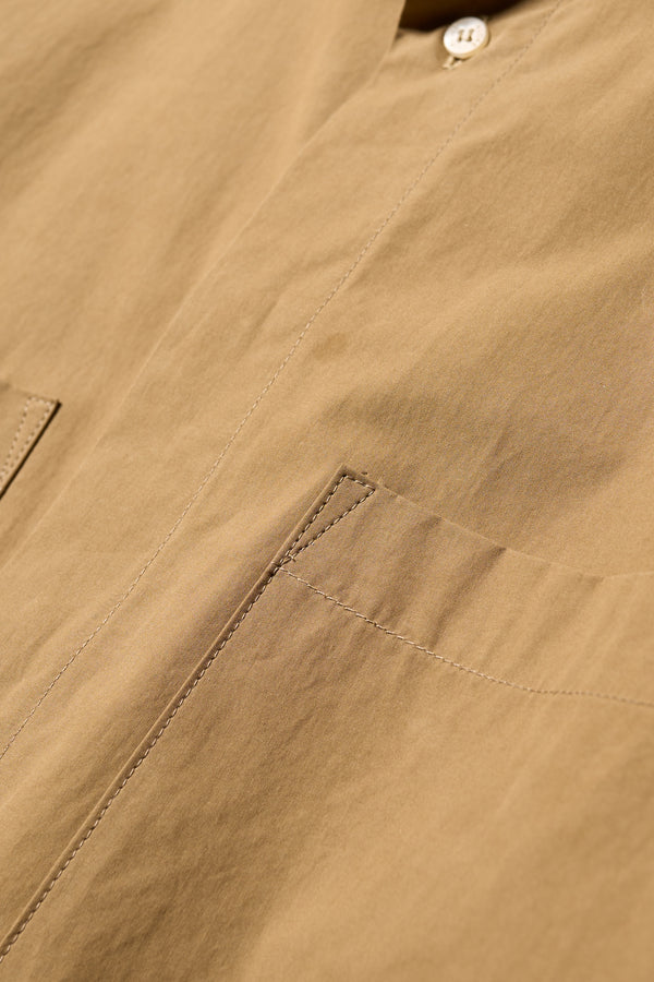 Close up fabric shot of the Offset Shirt in a dusty olive heavyweight cotton, featuring a relaxed fit and utility chest pockets.