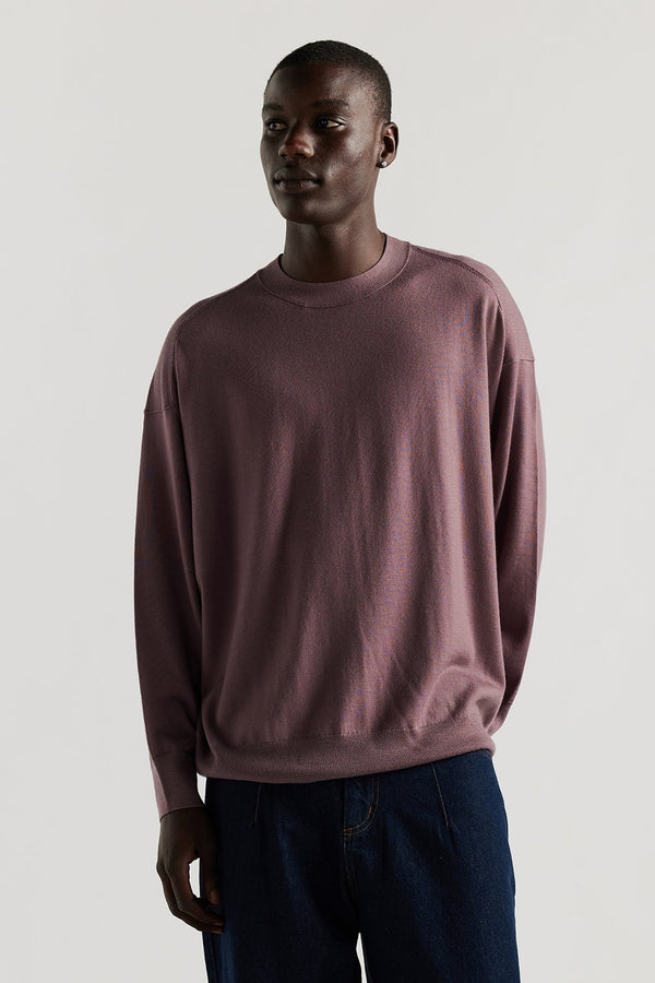 front of Male model wearing mauve refined merino wool crew neck jumper with relaxed fit, dropped shoulders, exposed seam detailing.