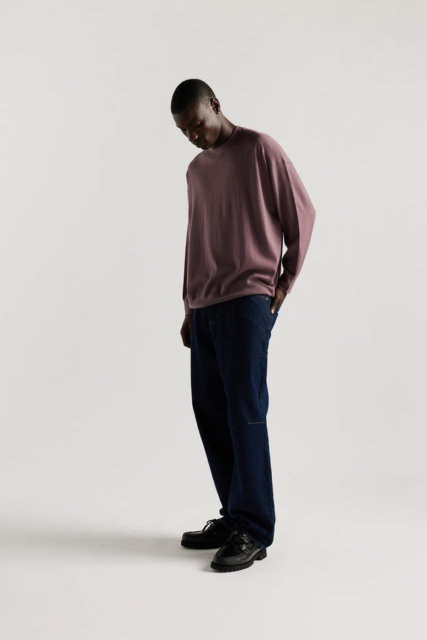 front of Male model wearing mauve refined merino wool crew neck jumper with relaxed fit, dropped shoulders, exposed seam detailing.