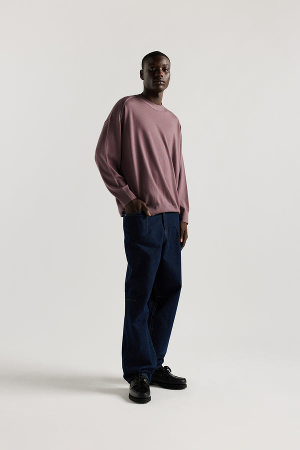 front of Male model wearing mauve refined merino wool crew neck jumper with relaxed fit, dropped shoulders, exposed seam detailing.