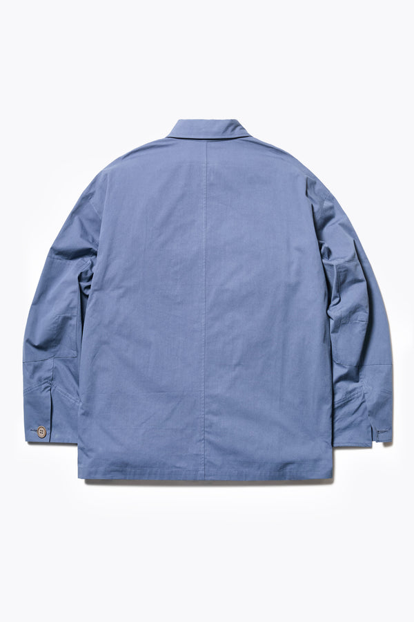 Back of The Pressure Jacket in Blue, a relaxed boxy long sleeve jacket in washed cotton herringbone with 3D patch pockets and hidden zip openings. Available in 5 sizes. 