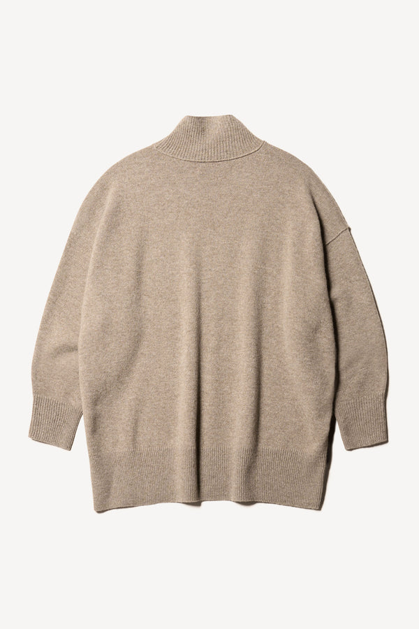 Flat back of the Prism mock neck merino wool fisherman sweater with exposed seams in Taupe. 