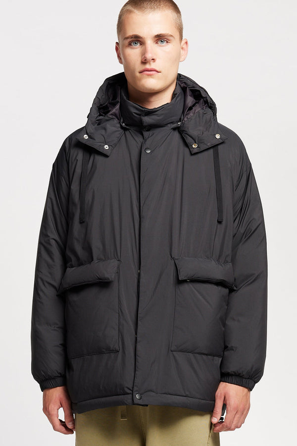 Front view of model the  Men’s Prospect Down Puffa a technical jacket with removable hood and utility pockets, made from recycled nylon. In black 