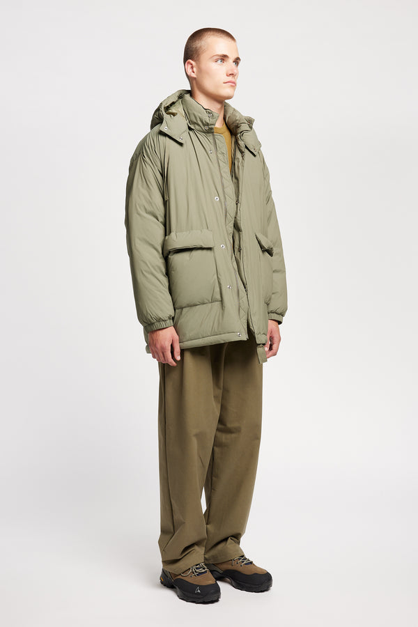 Front view of model the  Men’s Prospect Down Puffa a technical jacket with removable hood and utility pockets, made from recycled nylon. In Dusty Olive Green 